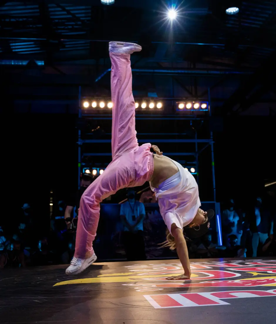 Breaker performing a handstand under stage lights